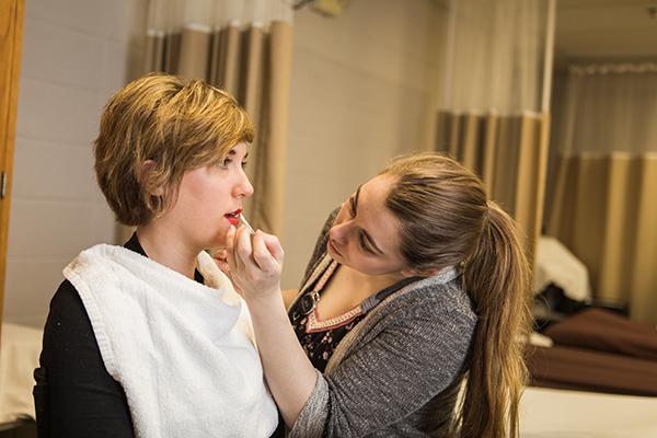 一位美容专业的学生正在给一位女士化妆