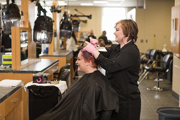 一位美容专业的学生在练习剪头发