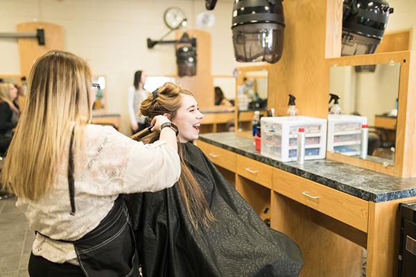一位美容专业的学生正在给一位女士做卷发